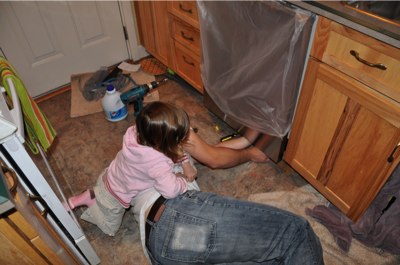 Ella helps dad install the dishwasher