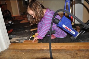 Ella helps install flooring.